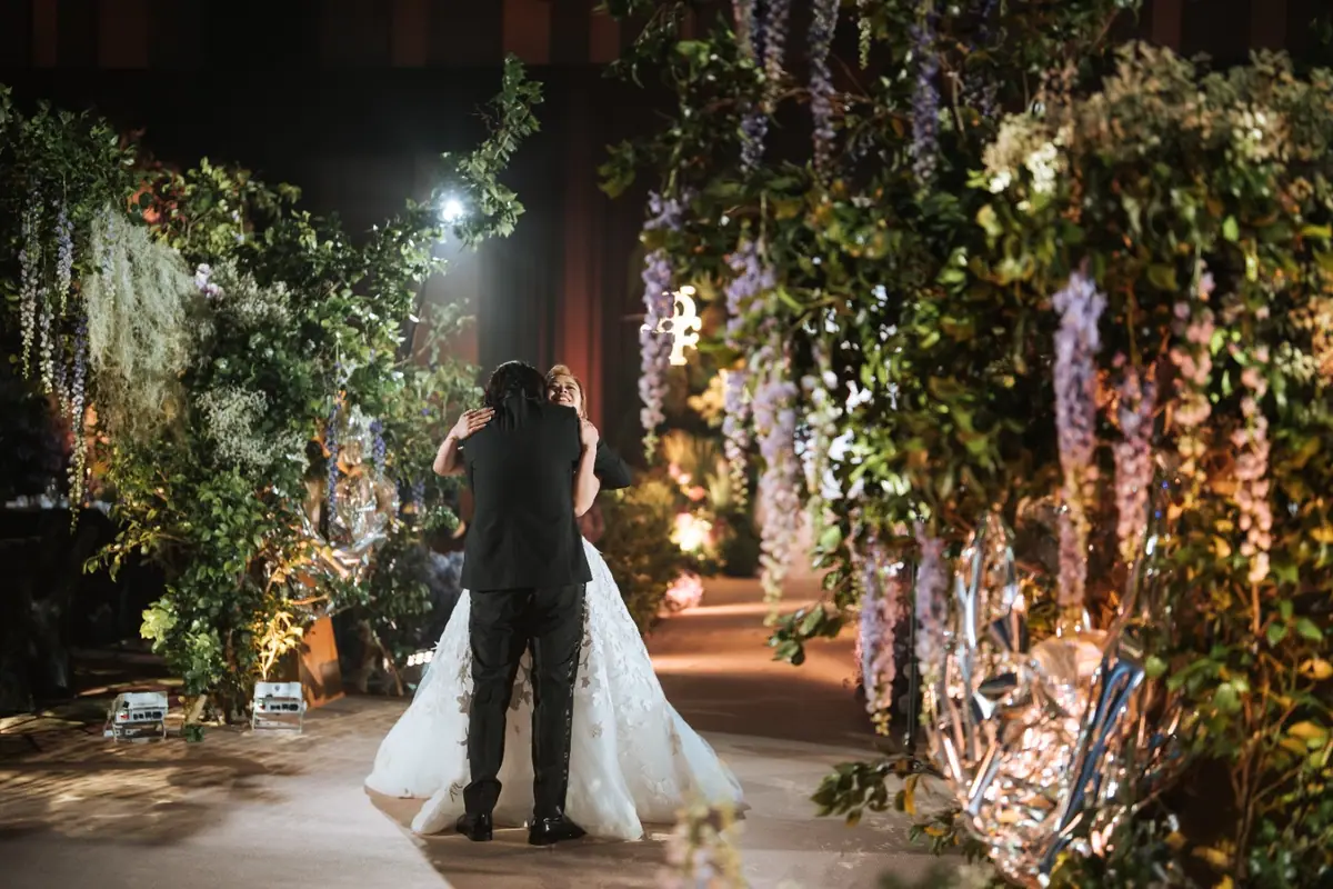 A couple dancing beneath hanging wisteria