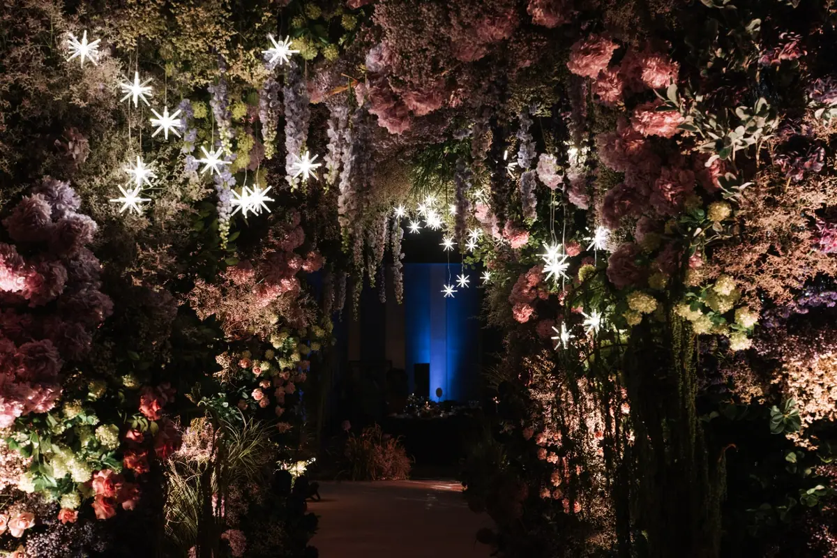 A flower-covered walkway lit with star lights