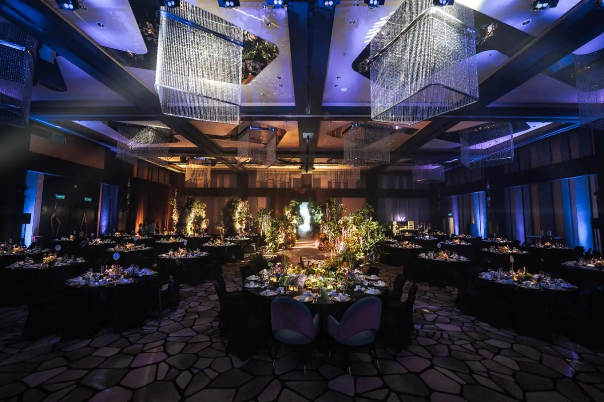 A ballroom set for dinner under chandeliers