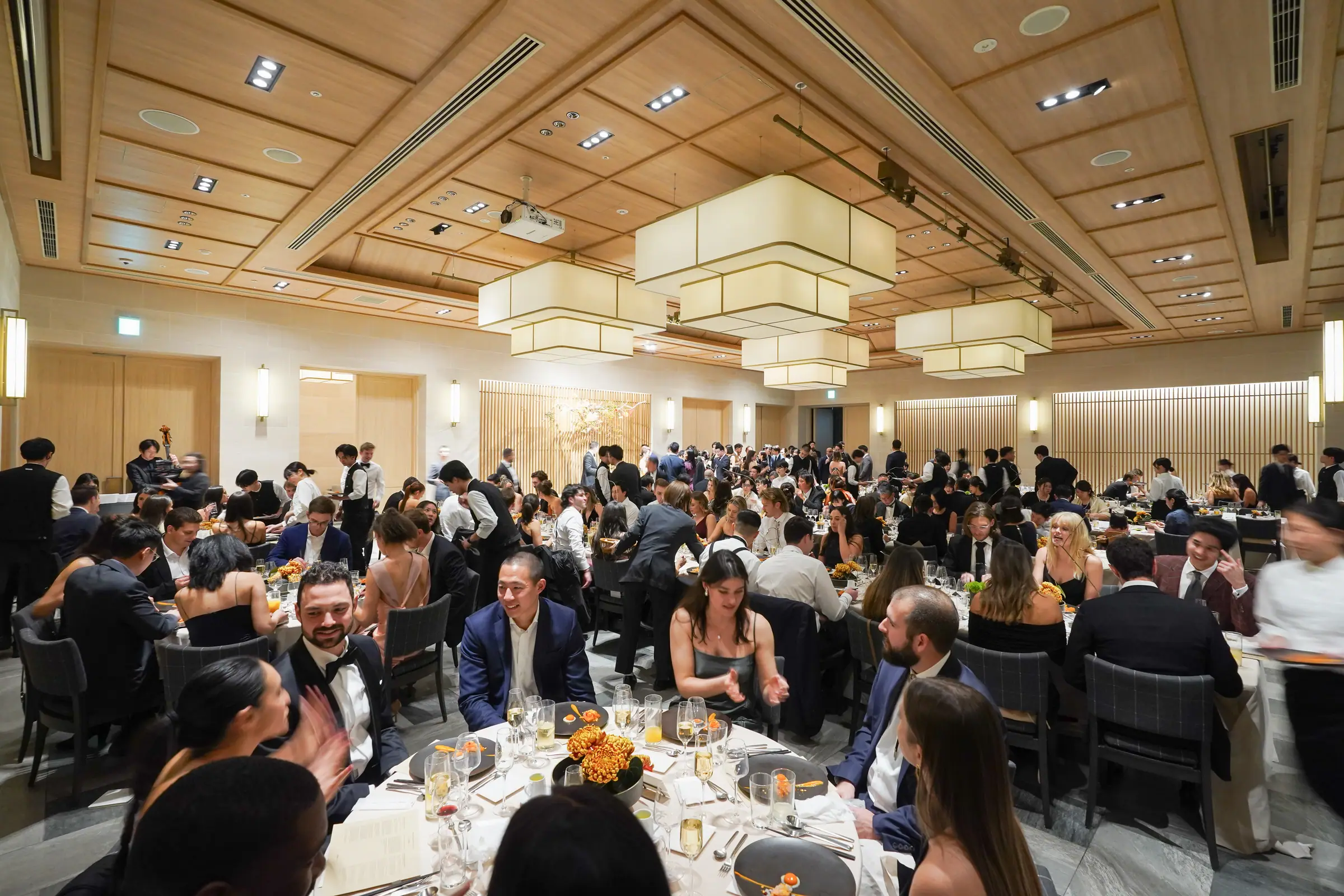 A wood-panelled reception room filled with guests at dinner