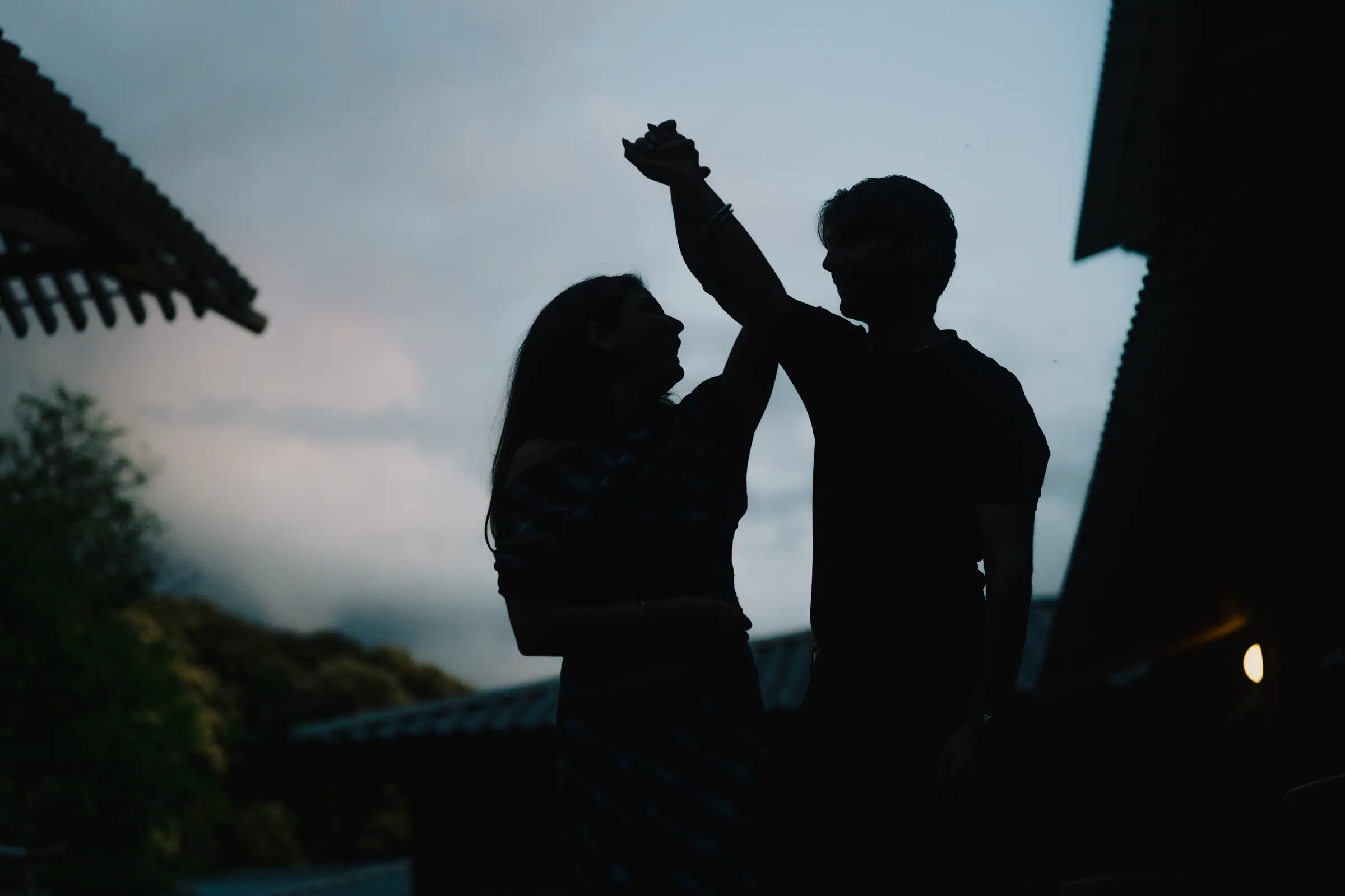 A couple dancing in silhouette against a dusk sky
