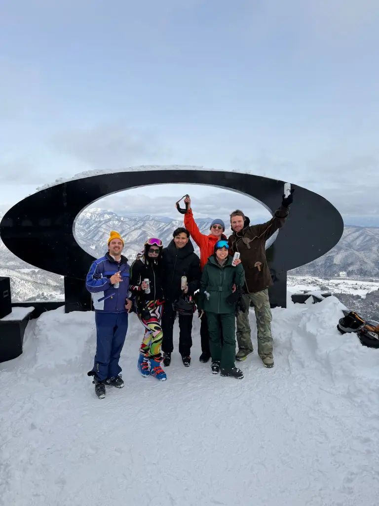 Group celebrating at ski summit in the mountains