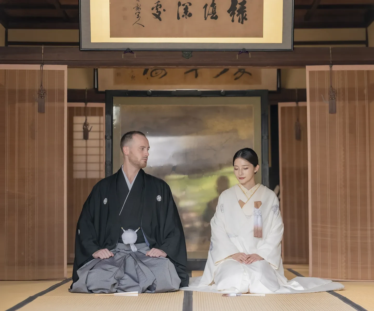 Couple in shiromuku and montsuki-hakama seated in a Japanese shrine hall during a Shinto wedding ceremony