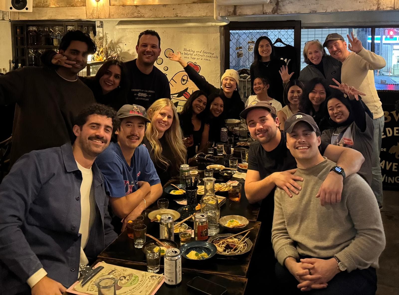 A group dinner at a Tokyo restaurant during our pre-wedding week, guests sharing food and drinks at a long table